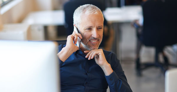 An individual is preparing to contact someone, focused and holding a device.