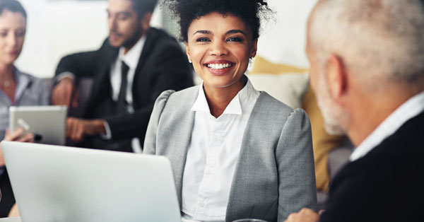 A woman holding a laptop while a man in formal clothes looks at her, as they discuss requesting a call back