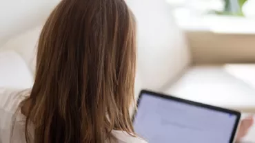 Woman using a laptop on a couch at home
