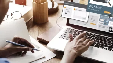 Person using a laptop for online job search.