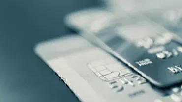 Close-up of three credit cards stacked on a table.