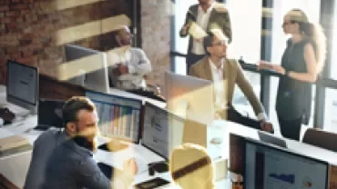 Team working collaboratively in a bright, modern office with computers and documents.