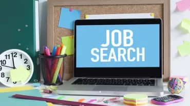 Laptop displaying 'Job Search' on a desk with office supplies.