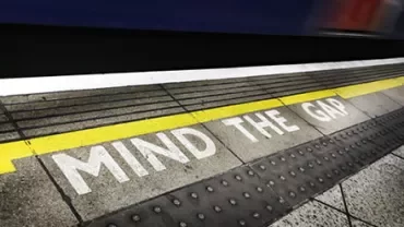 Platform edge with 'Mind the Gap' warning at a train station.