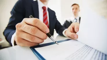 Businessman signing a document at a desk.