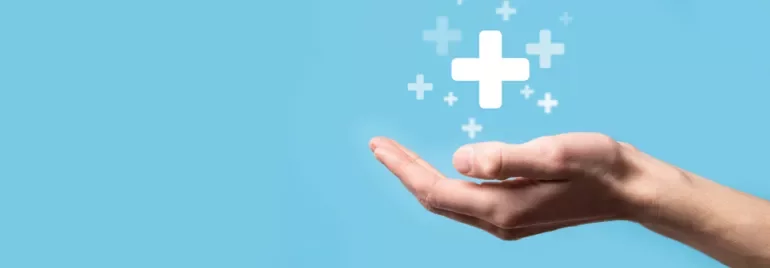Hand holding floating plus symbols on a blue background.
