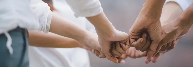 A group of diverse hands holding together in unity.