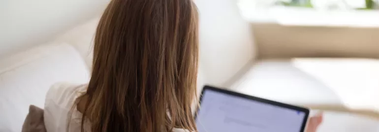Woman using a laptop on a couch at home
